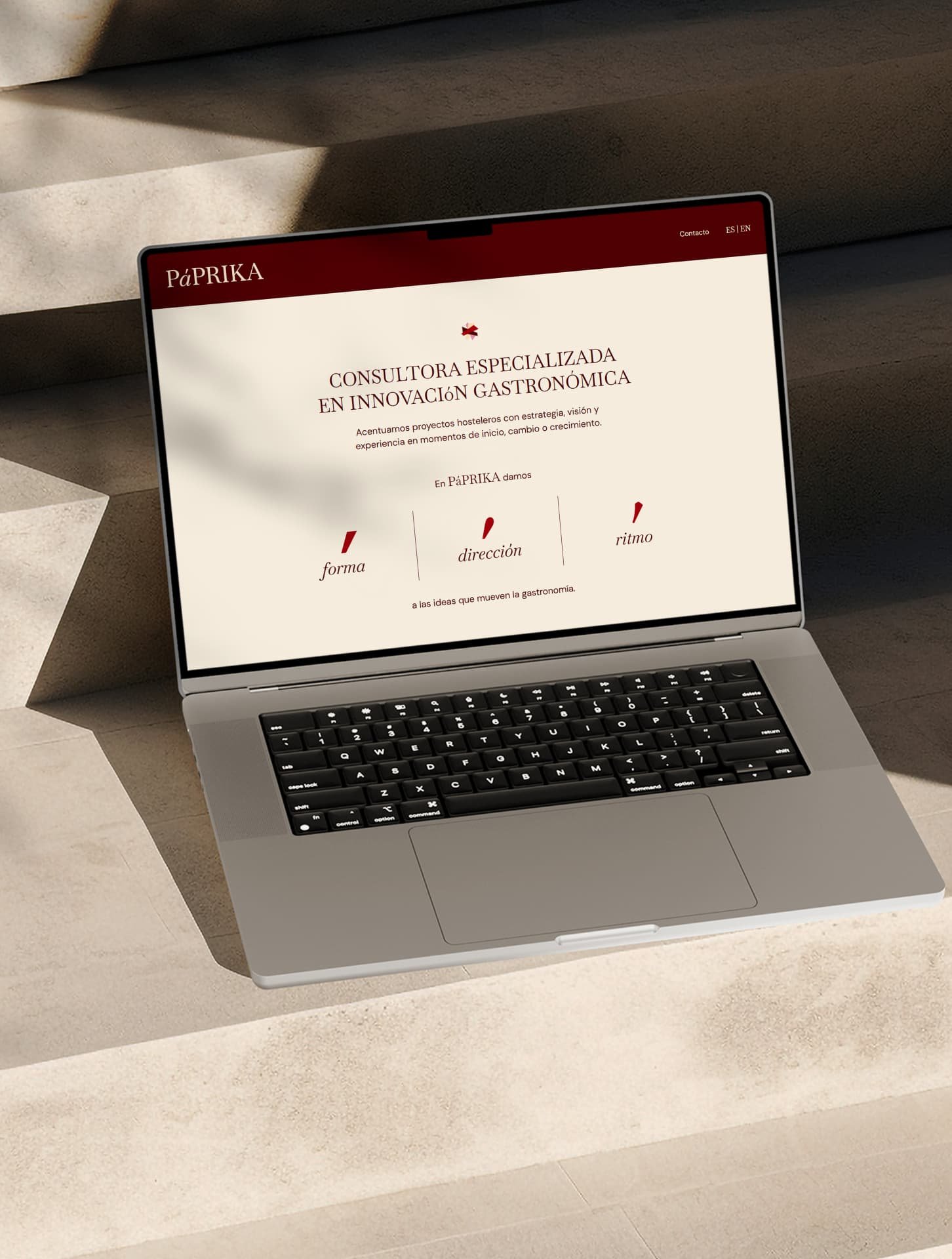 Páprika website shown on a laptop in warm daylight.