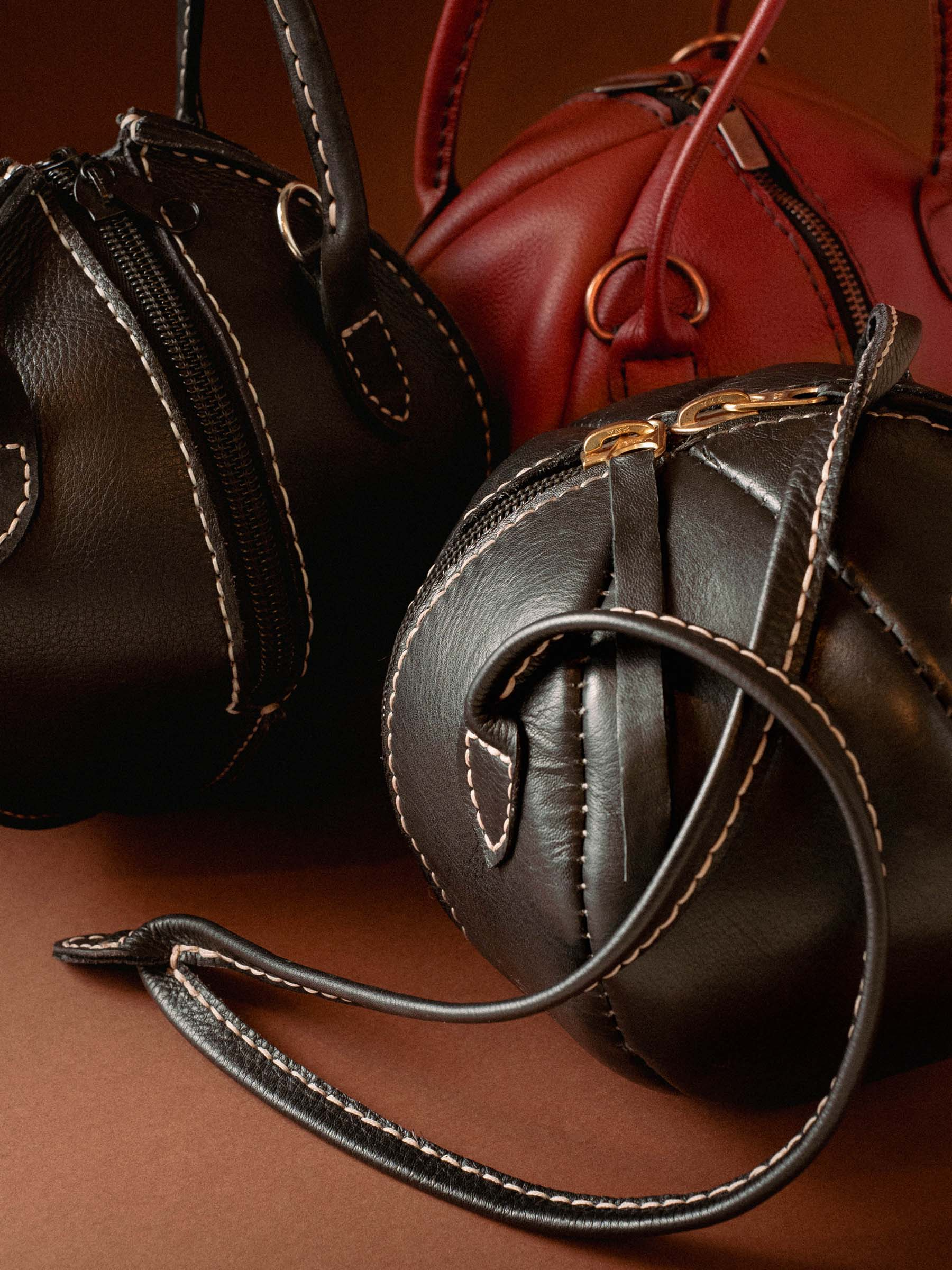 Vinito campaign image with a red round leather bag by the sea.